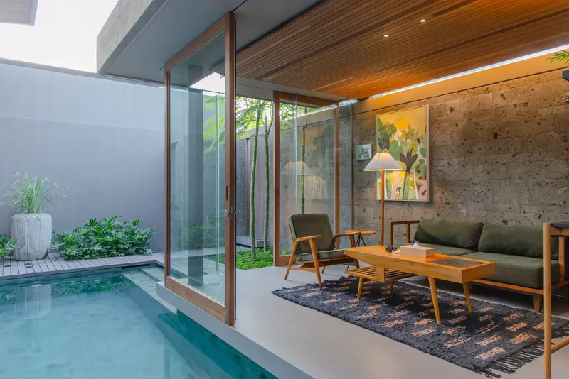 Villa lounge in Bali opening onto a plunge pool through sliding glass walls
